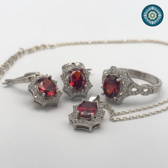 A commissioned silver suite of ring and earrings set with garnet stones